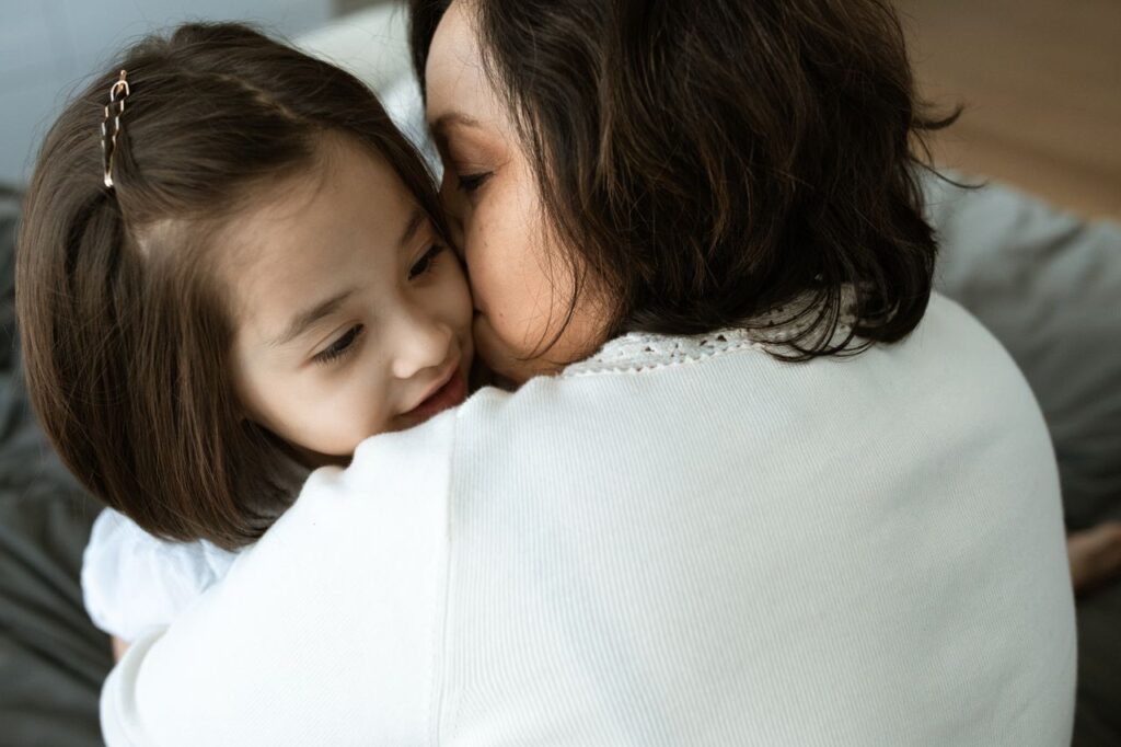Why We Partner with Families 4 Families A heartwarming close-up of a mother hugging her daughter, conveying affection and warmth.
