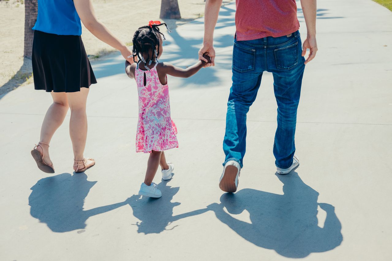 Crafting Captivating Headlines: Your awesome post title goes here A diverse family enjoying a sunny day, holding hands and walking together.